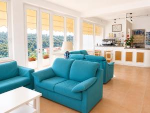 a living room with blue couches and a kitchen at Hotel Alma in Campo nell'Elba