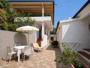 a patio with a table and chairs and an umbrella at Hotel Alma in Campo nell'Elba +16 photos
