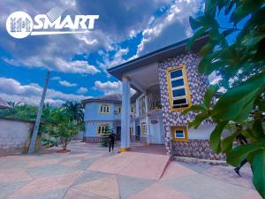 a man standing in front of a house at IMSMART Luxury Apartment in Uyo