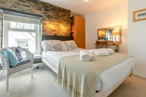 a bedroom with a bed and a chair in it at 4 Bed in Looe oc-l30051 in Looe
