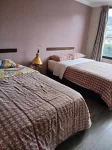 ein Schlafzimmer mit zwei Betten und einem Fenster in der Unterkunft Hotel Jomaley in Loja