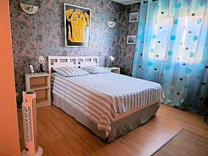 a bedroom with a bed with a striped comforter at LA BOUVIERE in Aulnat