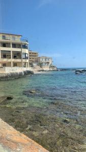 a building on the beach next to the water at Vespro 1 Apartment - near the Greek theater in Syracuse