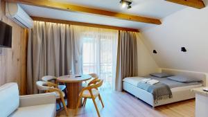 a bedroom with a bed and a table and chairs at Willa Magiera - widok na Trzy Korony in Sromowce Niżne +96 photos