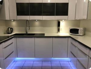 a kitchen with white cabinets and a microwave at Disney golden house in Magny-le-Hongre