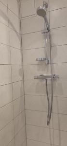 a shower with a shower head in a bathroom at Studio Le Mûrier in Saint-Martin-dʼHères