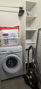 a washing machine in a room with a vacuum at Studio Le Mûrier in Saint-Martin-dʼHères +4 photos
