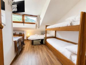 a room with two bunk beds and a tv at Hostdomus - Green Valley in Borgata Sestriere