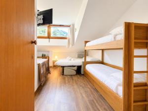 a room with two bunk beds and a window at Hostdomus - Green Valley in Borgata Sestriere