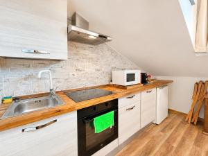 a kitchen with a sink and a microwave at Hostdomus - Green Valley in Borgata Sestriere