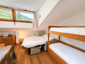 two bunk beds in a room with a window at Hostdomus - Green Valley in Borgata Sestriere +10 photos