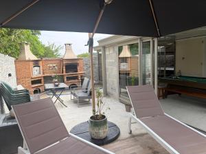 a patio with two chairs and a pool table at Evasion Suite parentale in La Couronne