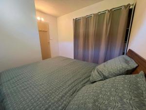a small bedroom with a bed and a curtain at Appartement 61 in La Ciotat