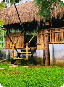 a hut with a straw roof with a table in front at The bharani villa in Pulpally