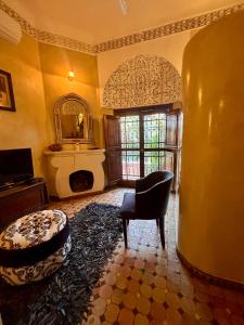 a living room with a chair and a fireplace at Palais El Arsat & Spa in Marrakesh