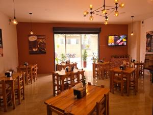 a restaurant with wooden tables and wooden chairs at Hotel Monarca in Medellín