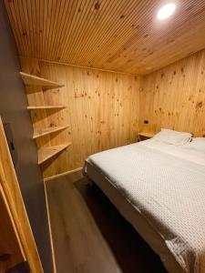 a bedroom with a bed and a wooden wall at Onix in Las Trancas