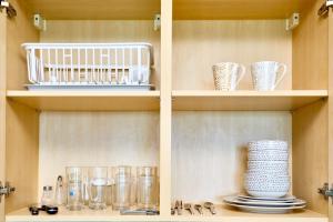 a shelf with glasses and cups on it at Grande Carribean apartments Jomtien beach Pool view Sea View in Pattaya South +21 photos