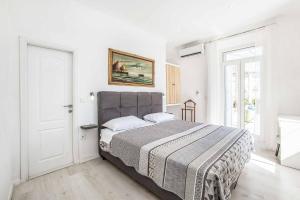 a bedroom with a large bed in a white room at Villa Adriatic Pearl in Dubrovnik +18 photos