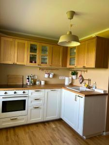 a kitchen with white cabinets and a white stove top oven at Mõnus peatuspaik Saaremaa põhjaranniku avastamiseks in Myustelʼ +12 photos