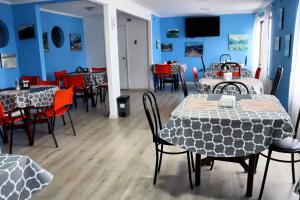 a dining room with tables and chairs and blue walls at HOTEL LOYOLA in Coihaique