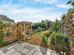 a garden with a wooden bench and a fence at 1 Bed in Chipping Campden oc-93393 in Chipping Campden