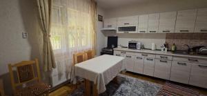 a kitchen with white cabinets and a table in it at Casa Danut in Vidra