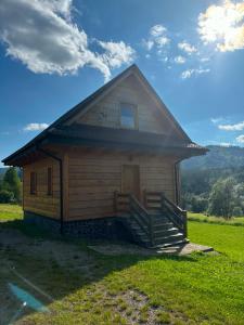 a small wooden house with a porch and stairs at Chaty u Bibra in Sablówka