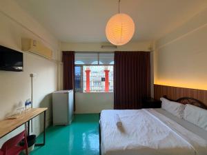 a bedroom with a white bed and a window at arakhouse อารักษ์เฮ้าส์ in Godown +5 photos