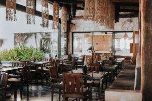 a dining room with wooden tables and chairs at Na Balam Hotel in Isla Mujeres