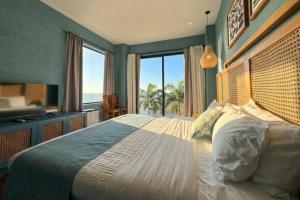 a bedroom with a large bed with a large window at Jama Campay Hotel by Otium in Los Camarones +95 photos