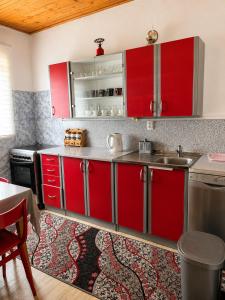 a kitchen with red cabinets and a sink at Apartment Aleksić in Žabljak