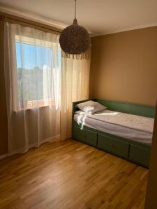 a bedroom with a bed and a large window at Mõnus peatuspaik Saaremaa põhjaranniku avastamiseks in Myustelʼ