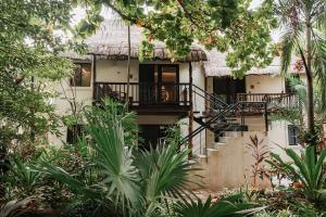 a house with a staircase and a thatch roof at Na Balam Hotel in Isla Mujeres
