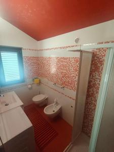 a bathroom with a toilet and a sink at La Terrazza in Carrao +27 photos