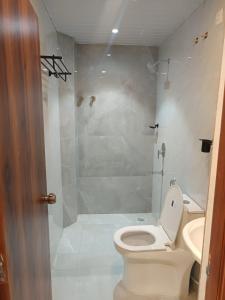 a bathroom with a white toilet and a shower at Hotel Tals Hitech - Nr Jubliee Enclave, Hitech CIty in Hyderabad +14 photos