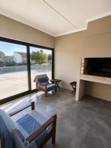 a bedroom with a large window and a fireplace at Die Ou Lady - Dwarskersbos in Velddrif