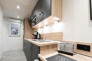 a small kitchen with a sink and a counter at Studio Le Saphir tout inclus petitdéjeuner in Éloyes