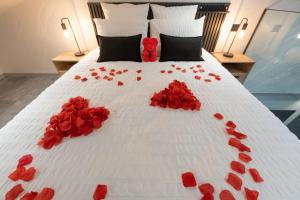 a bed with red rose petals on it at Studio Le Saphir tout inclus petitdéjeuner in Éloyes