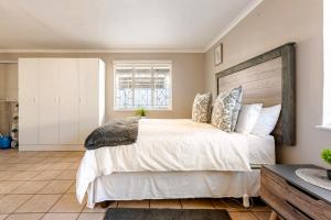 a bedroom with a large bed and a window at Hephzibah Manor in Alberton