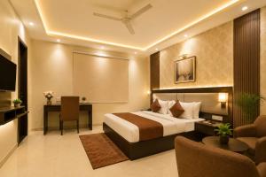 a hotel room with a bed and a desk at The Grand Olive Aero Suites Near Delhi Airport in New Delhi
