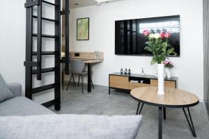 a living room with a vase of flowers on a table at Studio Le Quartz tout inclus petitdéjeuner in Éloyes
