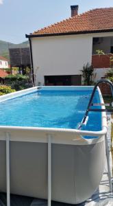 a large swimming pool in front of a house at Olive Roots Yard House in Trebinje