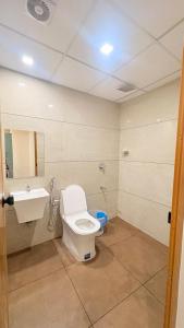 a bathroom with a toilet and a sink at Cozy Rooms & Dormitory in Kozhikode