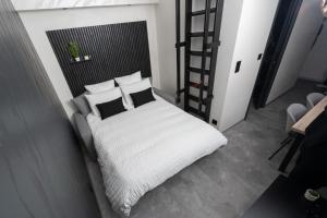 a bedroom with a bed with white sheets and pillows at Studio Le Cristal tout inclus petitdéjeuner in Éloyes