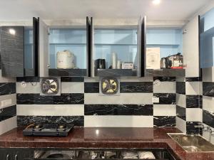 a kitchen with a black and white checkered wall at Prakash Bhawan in Darbhanga