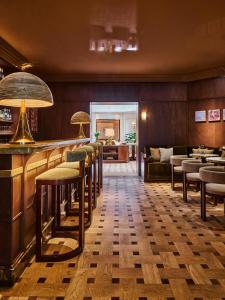 a bar with a row of stools in a restaurant at Hôtel Madison in Paris