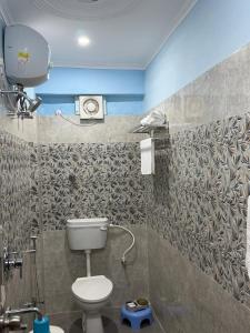 a bathroom with a toilet and a shower in it at Prakash Bhawan in Darbhanga +9 photos