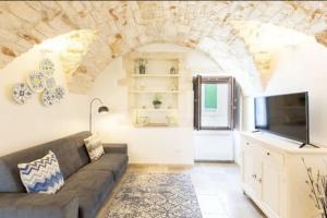 a living room with a couch and a tv at Casa Leo with Jacuzzi in Ostuni