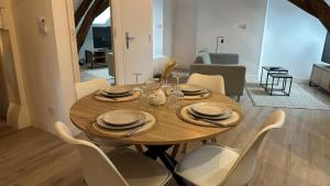a dining room with a wooden table and chairs at L'ombrelle in Chablis +13 photos